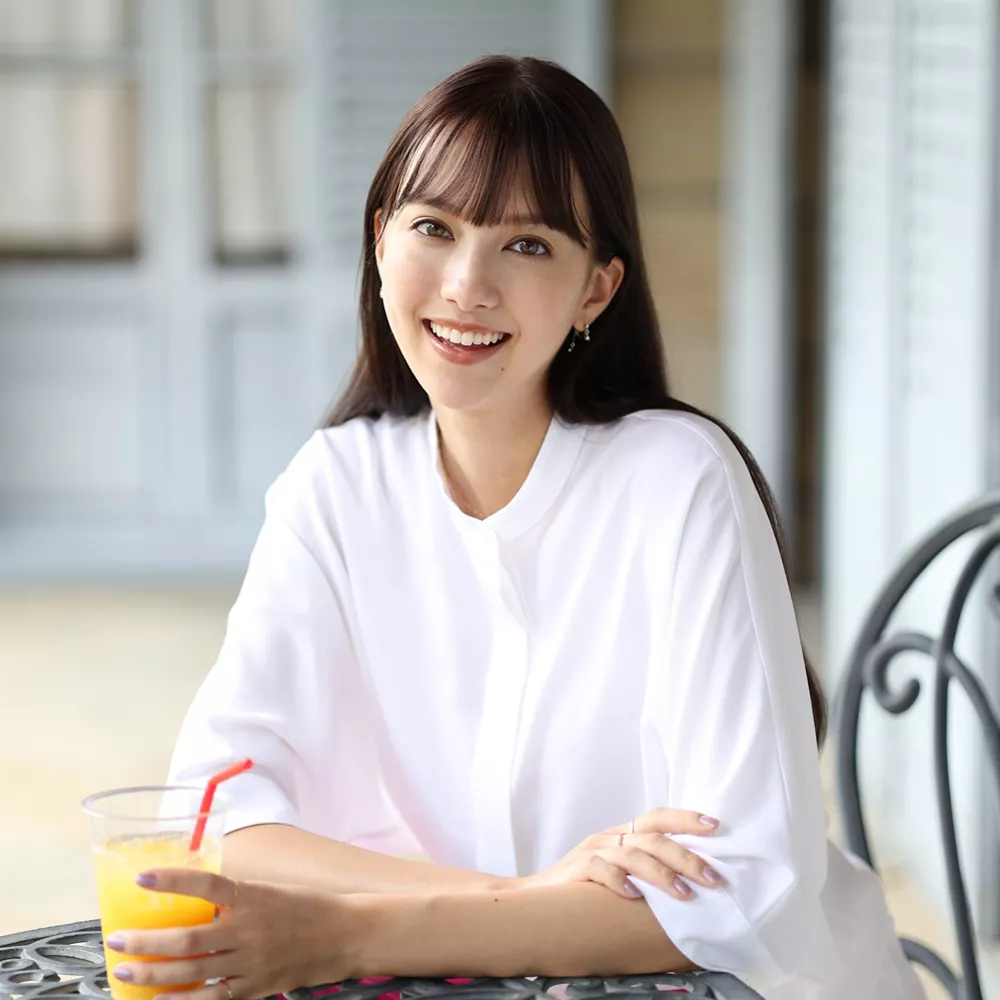 Person Sitting at a Coffee Table Drinking Orange Juice