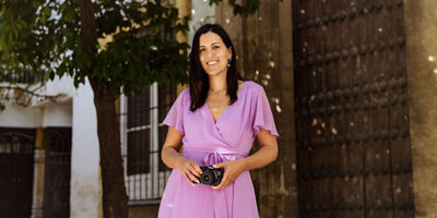 Woman in purple dress holding a Canon camera