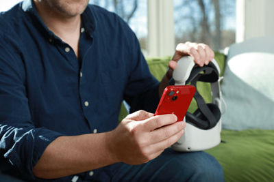 Person Holding the Canon Kokomo Headset and a Smart Phone