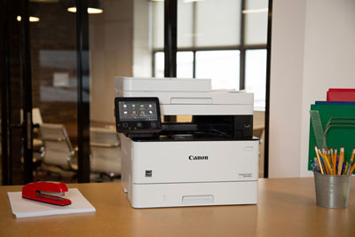 Laser Printer sits on a desktop with small office supplies