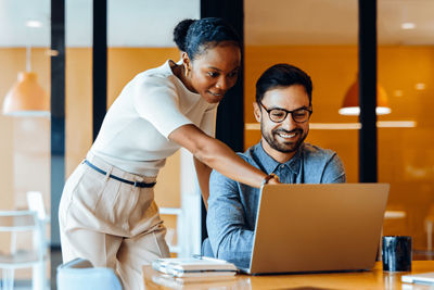 men and women working on a laptop computer