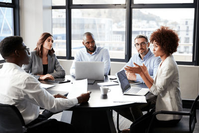 men and women working at a table in an office
