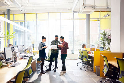 Four individuals in front of a white board discussing process