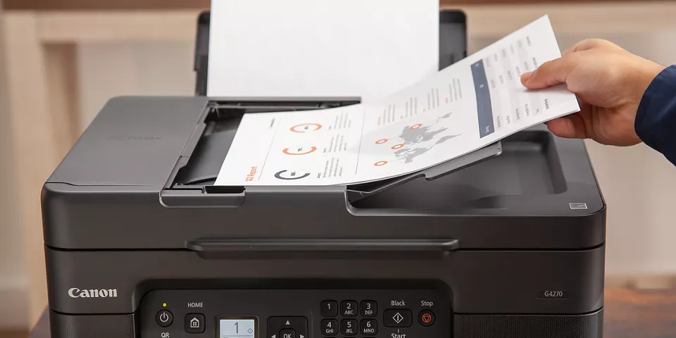 Person inputting a sheet to be scanned on the top tray of the PIXMA G4270
