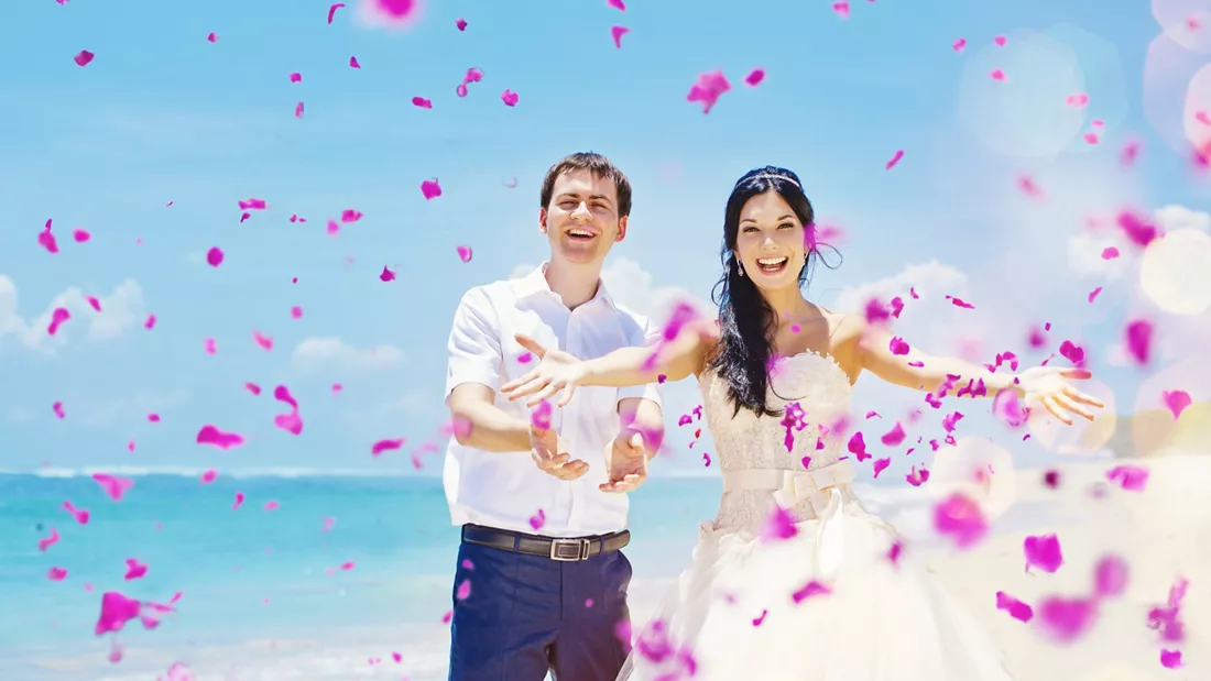 husband and wife throwing flower petals
