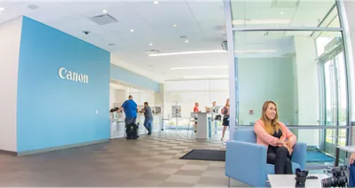 Office commonspace featuring a blue wall with Canon on it