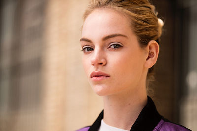 Portrait of fair-skinned blonde model with her hair pulled back and light reflecting softly off her face