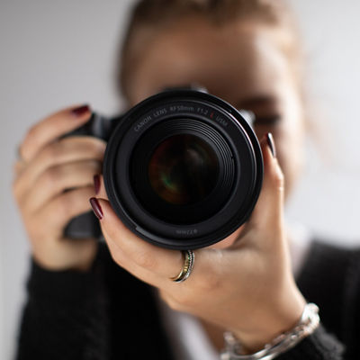 Close up image of woman pointing her camera lens at the screen