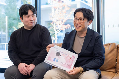 Hagiwara holding the original lens project proposal