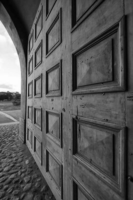 Black and white image of a wooden barn door with a stone embedded floor