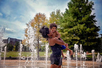 Person Lifting Up a Child While Playing in the Water