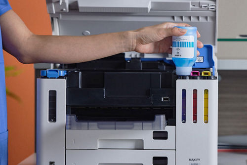 Refilling cyan ink in Canon MAXIFY printer.