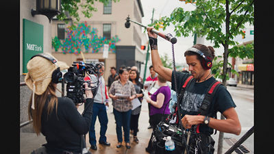 Person Holding a Microphone to Film a Scene