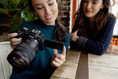Two women are looking at a camera and smiling