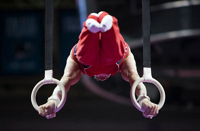 Gymnast doing a handhold position, using the circles to hold himself at a 90 degree angle
