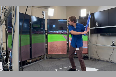 Person Swinging a Bat at a Simulation Baseball Game