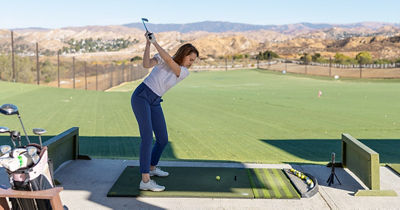 Person Practicing Golf at Driving Range