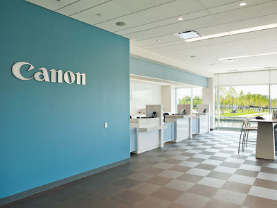 Interior office setting showcasing a blue wall with the Canon logo on it