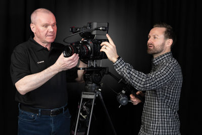 Two People Adjusting a Camera