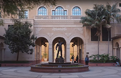 School entrance with arches and a statue