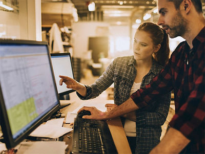 Print Service Professionals collaborating in front of a monitor