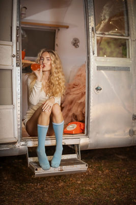 Person Sitting in a Trailer Drinking from a Glass Bottle