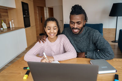 Father helping daughter study online