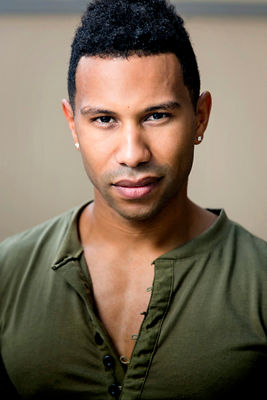 A young man, with a slightly parted green shirt