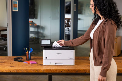 Person Retriving Printed Papers