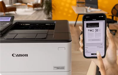 imageCLASS LBP246dw - Person Holding Mobile Phone In Front of Printer