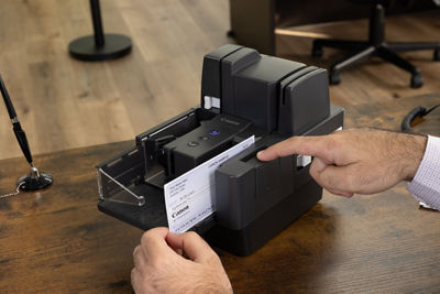 imageFORMULA CR-120 - 3 Quarter View of Person Scanning a Check