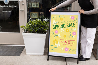 Person Putting up Printed Poster on a Sign