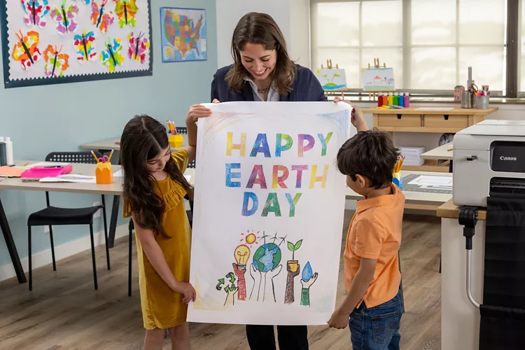 Profesora mostrando a los niños un cartel impreso