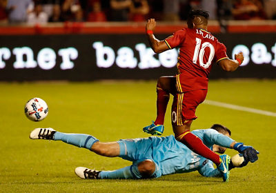 Soccer action image - one player slide tackeling and another jumping over him