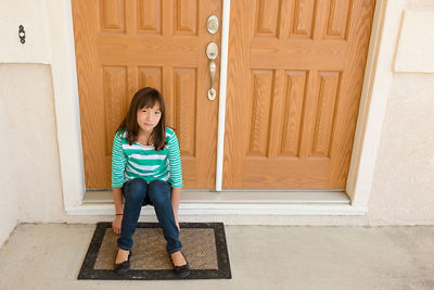 Child Sitting in Front of a Door