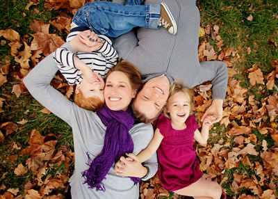 photo of family lying in grass and leaves