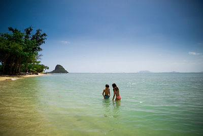 Laura's kids in the water with Chinaman's Hat small in the background