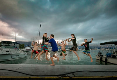 Group of children jumping off a pier