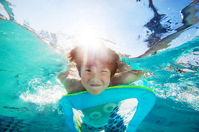 Photo of boy smiling under water in a pool