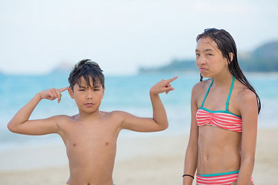 Laura's kids posing grumpily on the beach