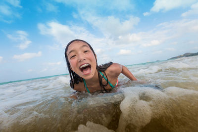 Laura's daughter boogie boarding toward the camera where the waves meet the sand