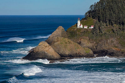 Coastal image of blue waves under a lighthouse on the cliff