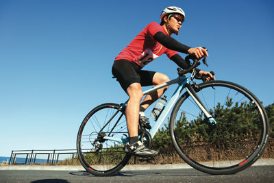 A male cyclist on his bike dressed in suitable gear.