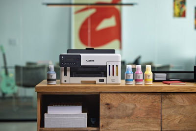 MAXIFY GX5120 - Front View on a Desk with Ink Bottles Next to it