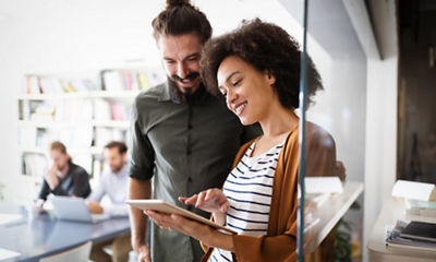 Image of a man and a woman working on a tablet