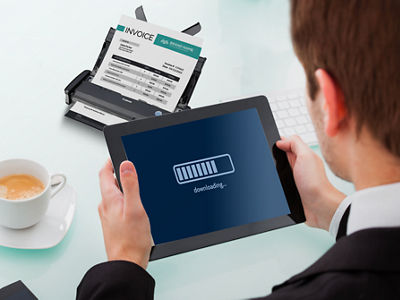 Man holding a tablet to communicate with a Canon scanner.