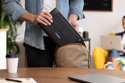 Person Putting the PIXMA TR160 Into a Bag