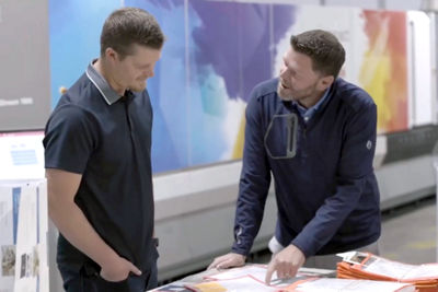 Two men working with a Canon Production Printer