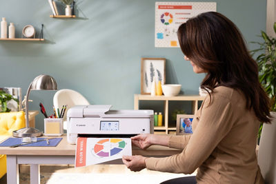  Woman at desk holding printed color wheel from Canon printer.