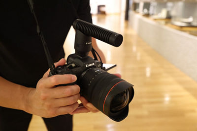 RF10-20mm F4 L IS STM - Person Holding Camera with Microphone